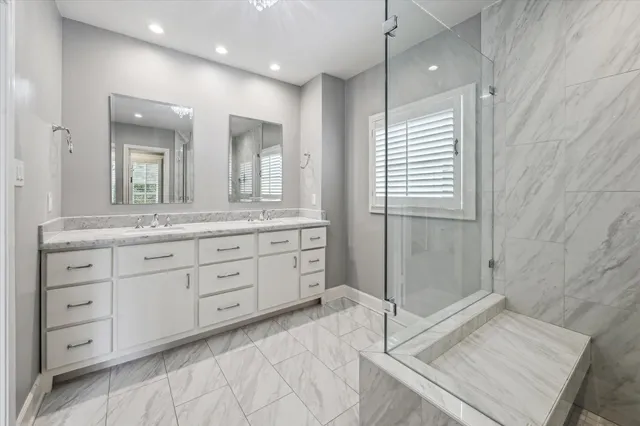 a spacious bathroom with a granite countertop sink mirror and shower