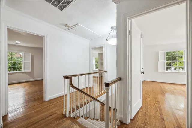 a view of a hallway with wooden floor and stairs