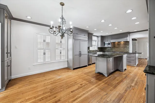a kitchen with stainless steel appliances kitchen island granite countertop a refrigerator and a sink