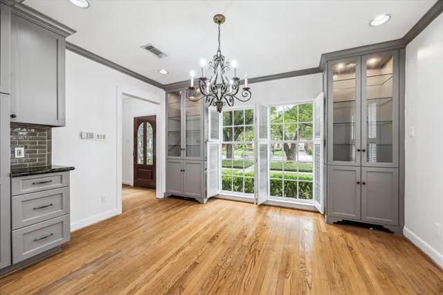 a view of a big room with wooden floor chandeliers and kitchen view
