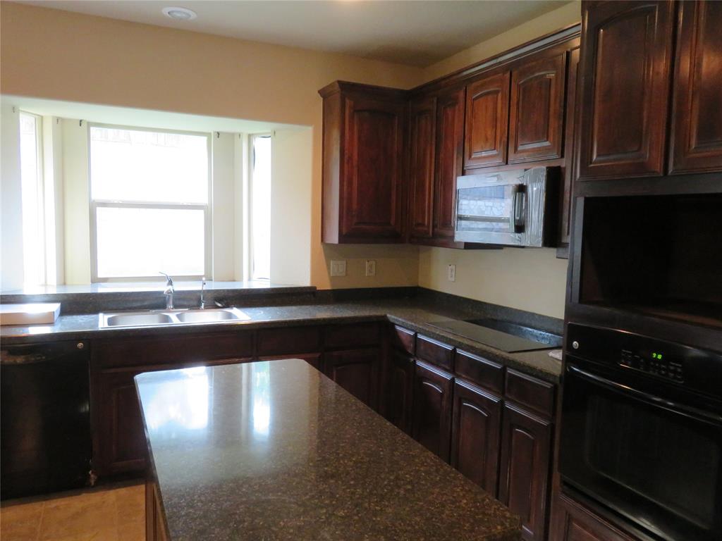 1122 Walter Stephenson Road Midlothian, TX 76065 - Photo 9 of 26 Kitchen featuring dark wood cabinetry, a built-in oven, integrated microwave, and a black cooktop