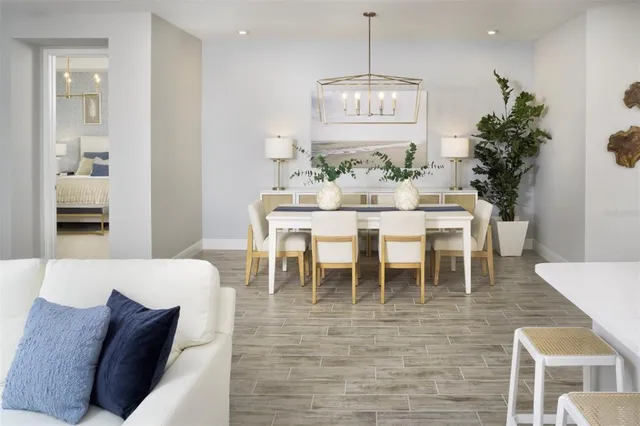 a living room with furniture a flat screen tv and kitchen view