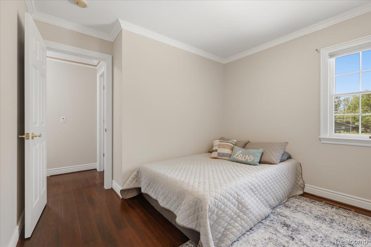 5685 Crescent Road Waterford, MI 48327 - Photo 23 of 47 Room featuring wood-finish flooring, white trim, a large window with white framing, light-toned walls, and crown molding