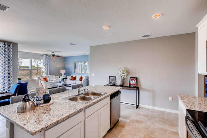 12348 Arabella Drive Port St. Lucie, FL 34987 - Photo 3 of 26 a kitchen with granite countertop a sink and a stove top oven