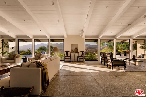 a view of a patio with dining table and chairs