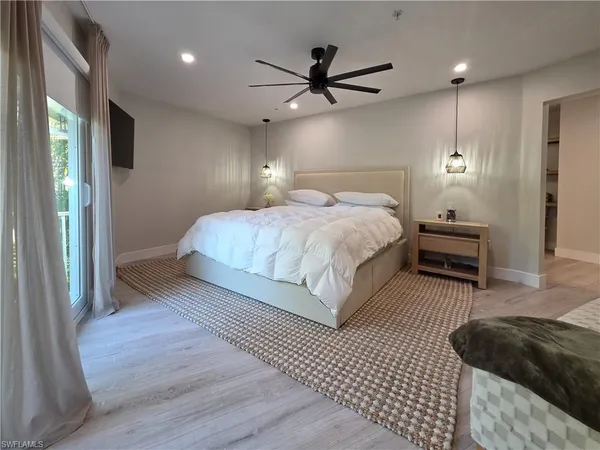 a bedroom with a bed a ceiling fan and a rug