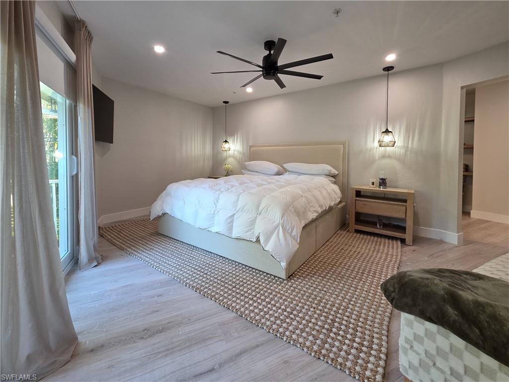 1495 Blue Point Avenue, Unit C Naples, FL 34102 - Photo 13 of 21 a bedroom with a bed a ceiling fan and a rug