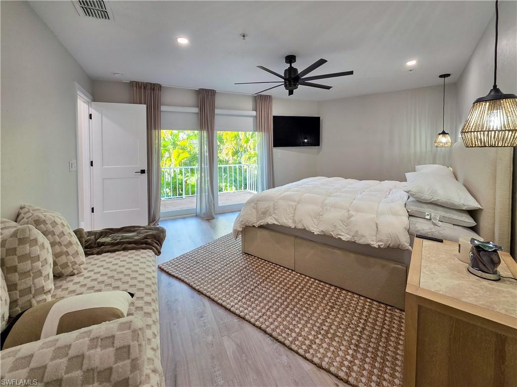 1495 Blue Point Avenue, Unit C Naples, FL 34102 - Photo 15 of 21 a bedroom with a bed and a flat screen tv