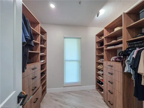 a view of walk in closet with clothes and shoes