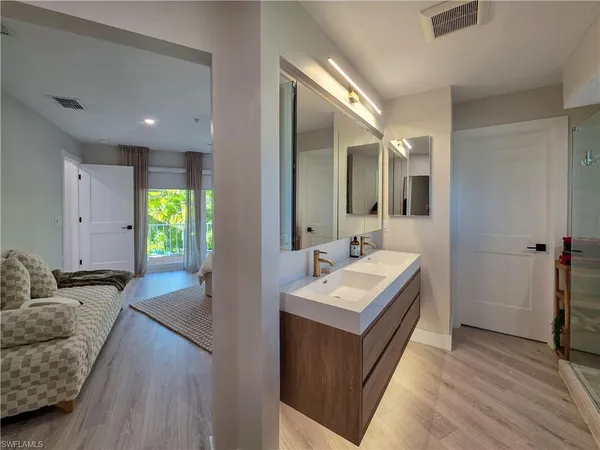 a en suite bathroom with a granite countertop sink and a mirror