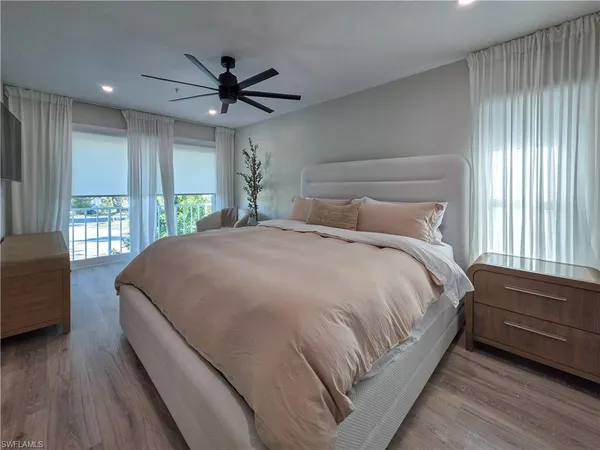 a bed sitting in a spacious bedroom next to a window