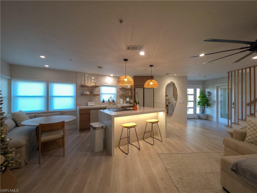 1495 Blue Point Avenue, Unit C Naples, FL 34102 - Photo 5 of 21 a dining area with furniture a large window and wooden floor