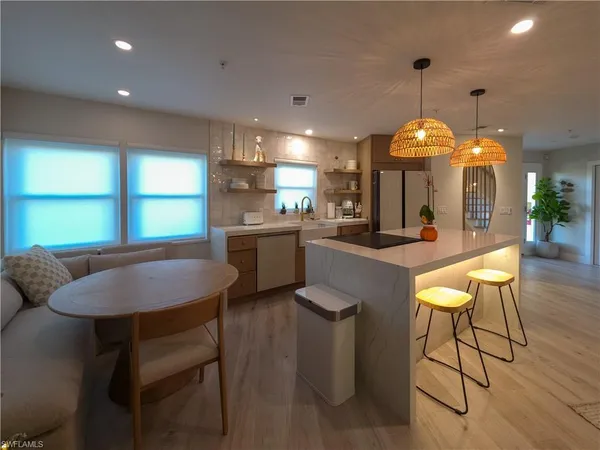 a kitchen with a dining table chairs sink and cabinets