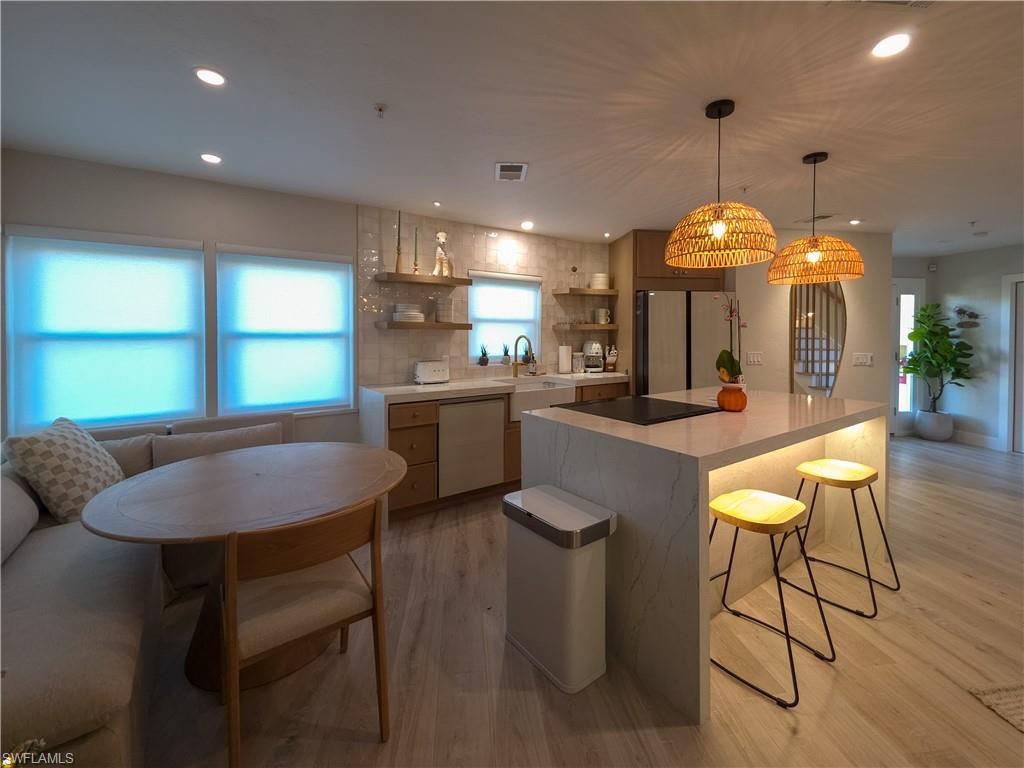 1495 Blue Point Avenue, Unit C Naples, FL 34102 - Photo 6 of 21 a kitchen with a dining table chairs sink and cabinets