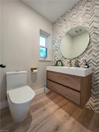 a bathroom with a sink mirror vanity and toilet