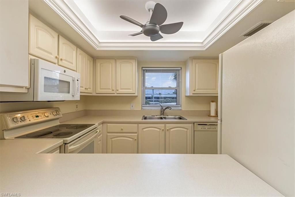 5483 Rattlesnake Hammock Road, Unit B201 Naples, FL 34113 - Photo 9 of 22 a kitchen with stainless steel appliances granite countertop a sink window and cabinets