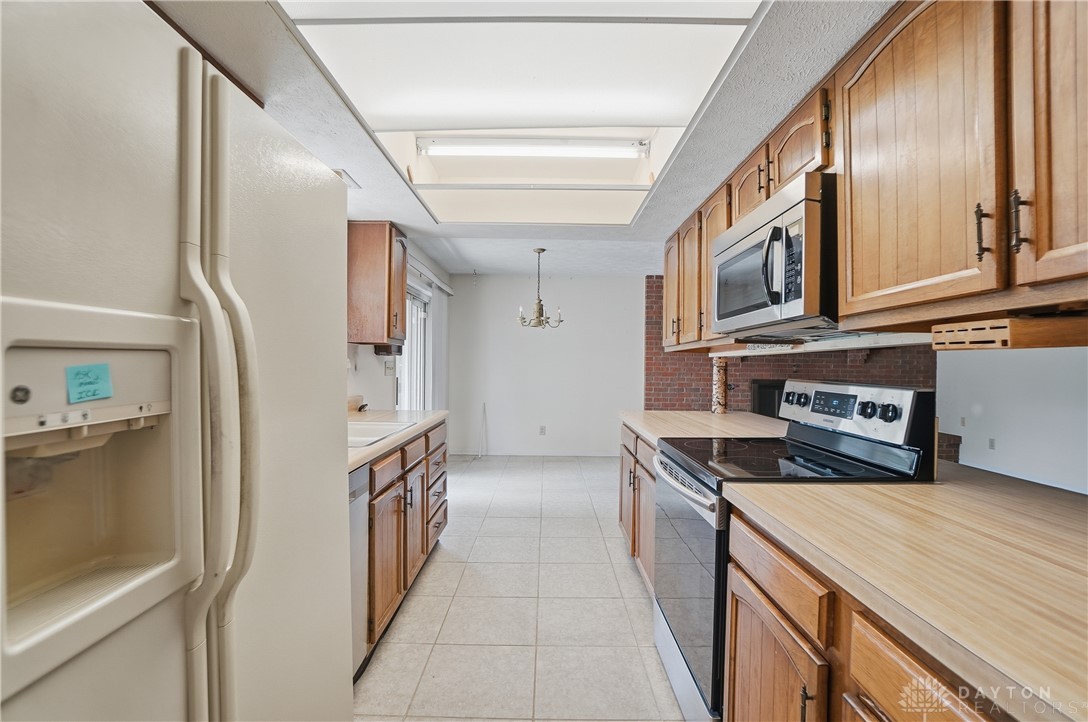 9964 Hummingbird Way Dayton, OH 45458 - Photo 15 of 57 This spacious kitchen offers a bright and functional space for culinary endeavors and casual dining.