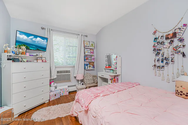 a bedroom with a bed and a flat tv screen in it