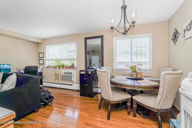 a dining room with furniture a chandelier and wooden floor