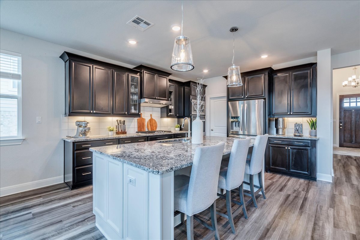 212 Sierra Blanca Road Dripping Springs, TX 78620 - Photo 9 of 37 Open kitchen with gas range and stainless steel appliances.