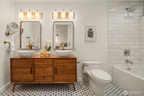 a bathroom with a toilet a sink tub and mirror