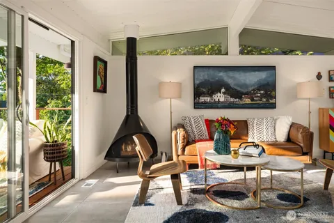 a living room with furniture and a painting on the wall