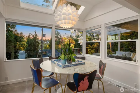 a view of a dining room with furniture large windows and wooden floor