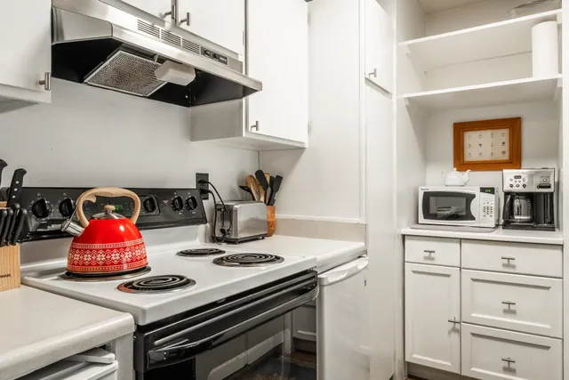 a kitchen with kitchen island a sink a stove and wooden cabinets