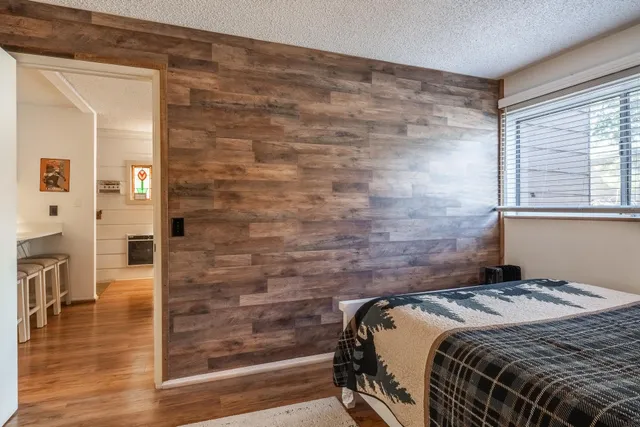 a bedroom with a bed and wooden floor