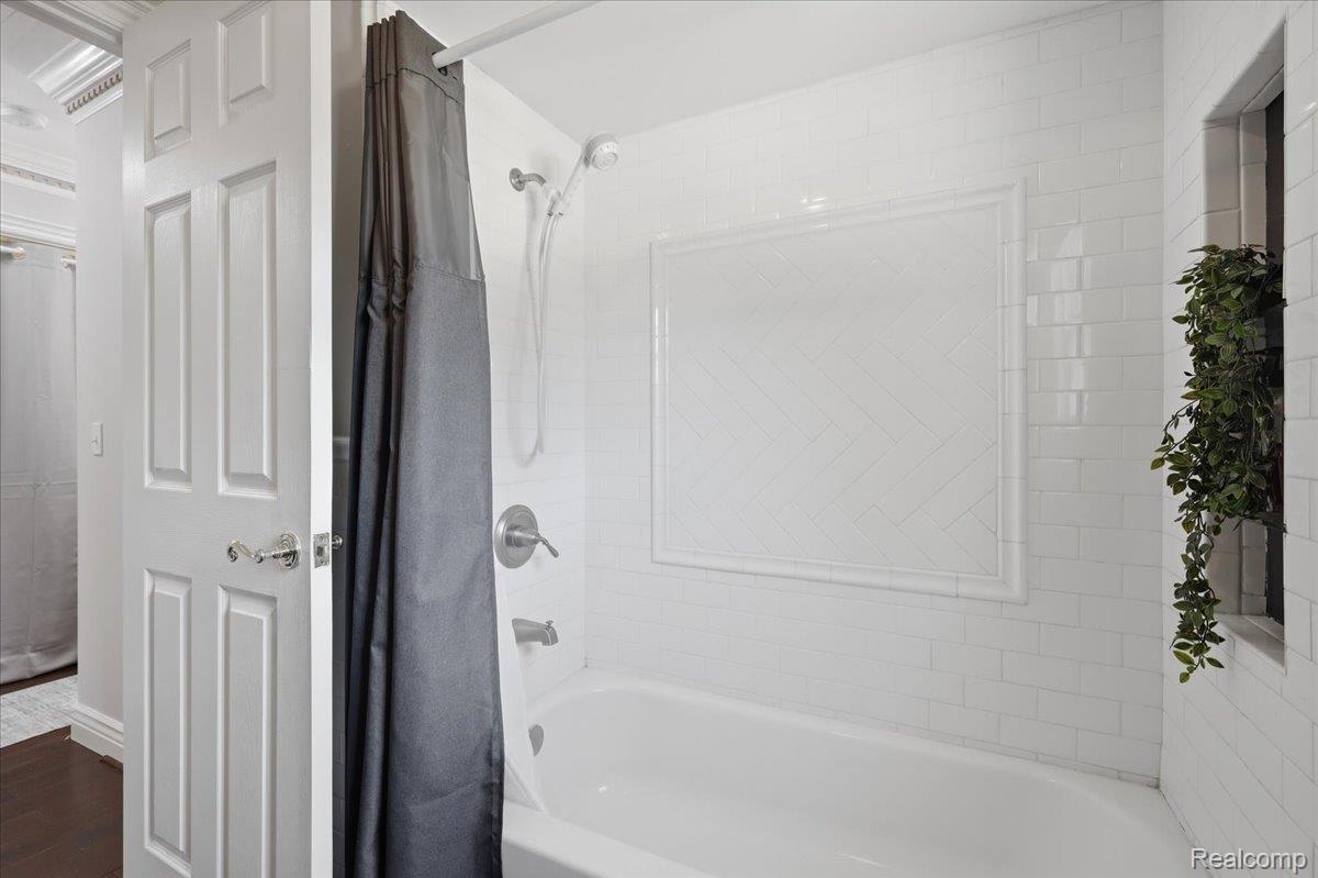 5685 Crescent Road Waterford, MI 48327 - Photo 30 of 47 Bathroom featuring a white subway tile surround with a herringbone pattern detail, built-in bathtub, and a chrome shower fixture