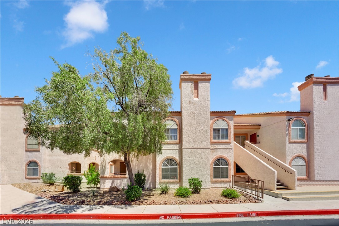7570 West Flamingo Road, Unit 115 Las Vegas, NV 89147 - Photo 30 of 34 Multi-level complex featuring Mediterranean-inspired architecture and desert landscaping, offering a blend of privacy and community.