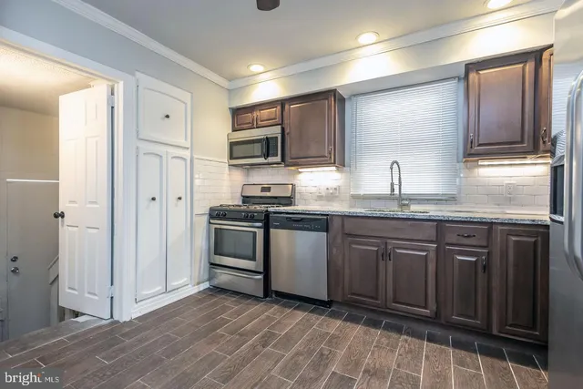 a kitchen with stainless steel appliances granite countertop a refrigerator and a stove top oven