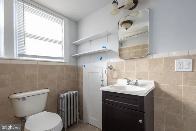 a bathroom with a toilet sink and mirror