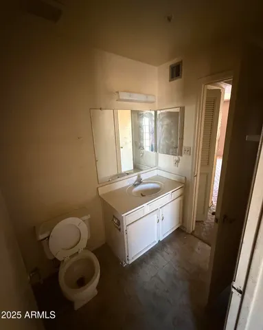 a bathroom with a granite countertop sink mirror vanity and toilet