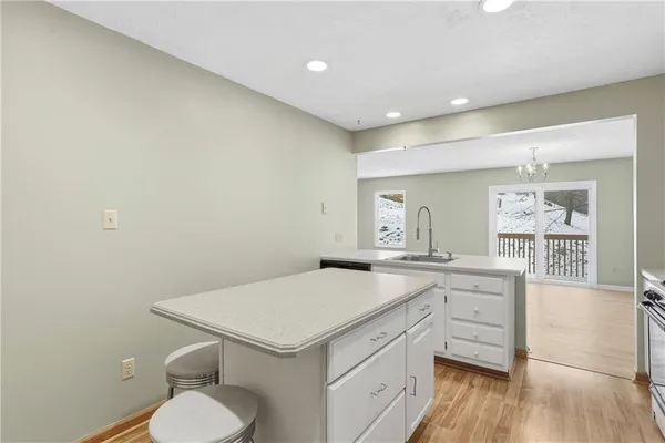 a kitchen with a sink a stove cabinets and wooden floor