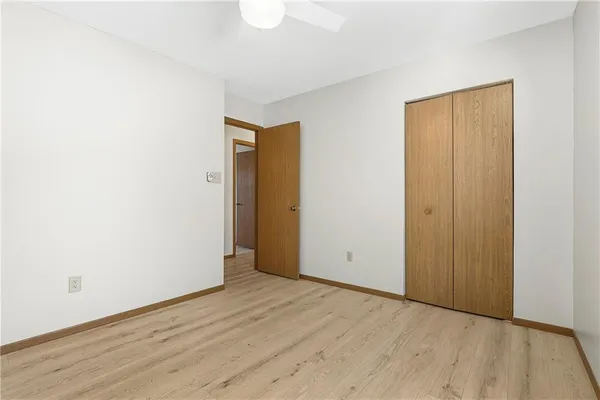 an empty room with wooden floor and closet area