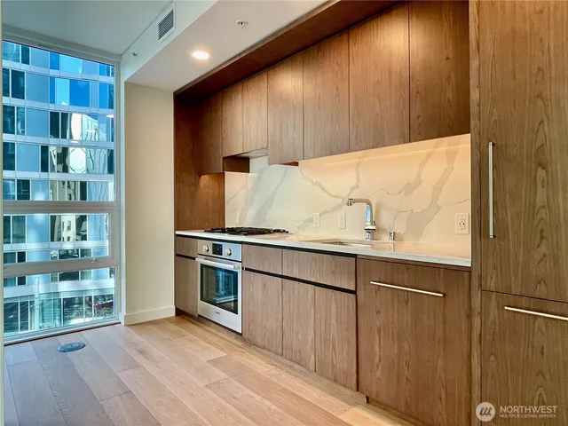 a view of kitchen with stainless steel appliances granite countertop cabinets and wooden floor