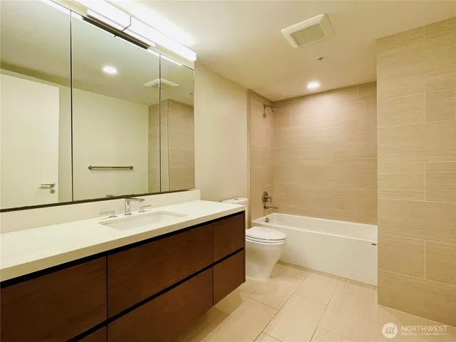 a bathroom with a double vanity sink toilet mirror and bathtub