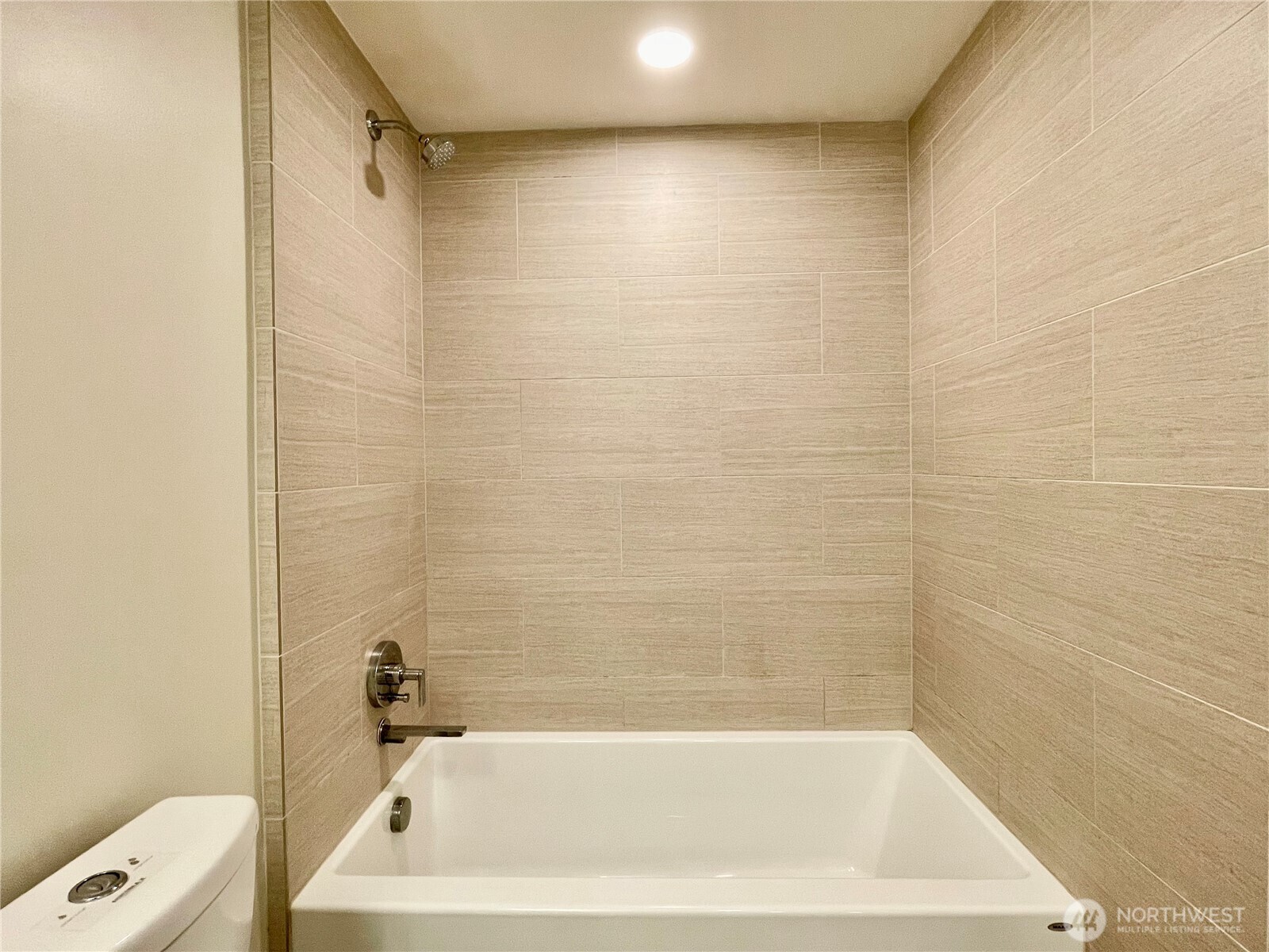 121 Stewart Street, Unit 401 Seattle, WA 98101 - Photo 26 of 29 a bath tub sitting next to a white sink and a shower
