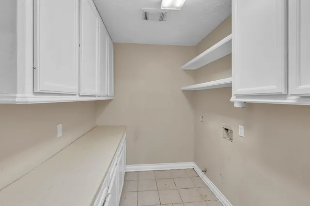 a view of cabinets and utility room with closet