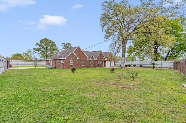 a view of a house with a big yard and large trees