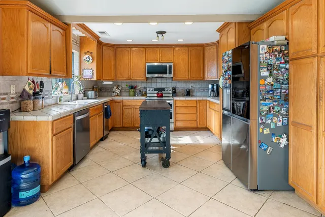 a kitchen with stainless steel appliances granite countertop a refrigerator and a stove top oven