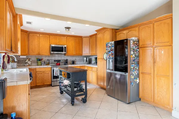 a kitchen with stainless steel appliances granite countertop a refrigerator and a stove top oven