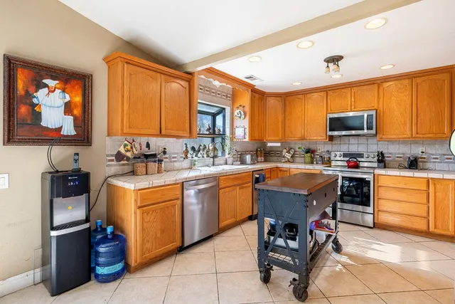 a kitchen with stainless steel appliances granite countertop a stove top oven a sink dishwasher and cabinets
