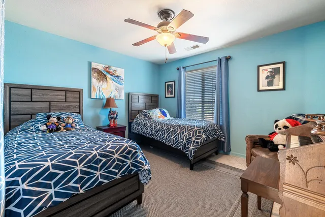 a bedroom with two beds and window