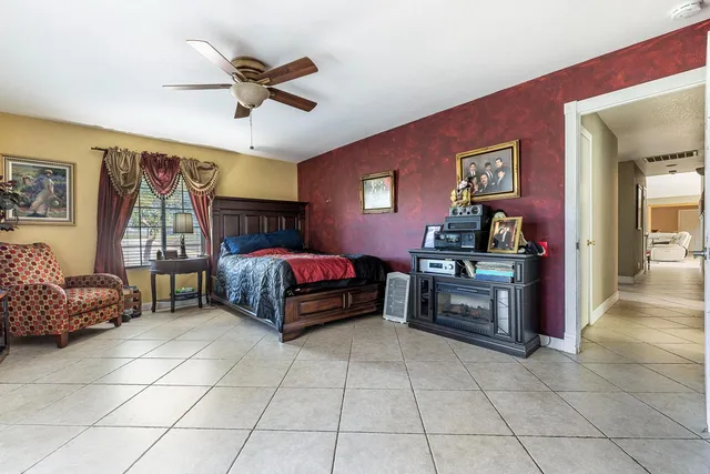 a bedroom with a bed and a ceiling fan