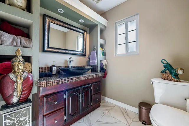a bathroom with a toilet a sink and mirror