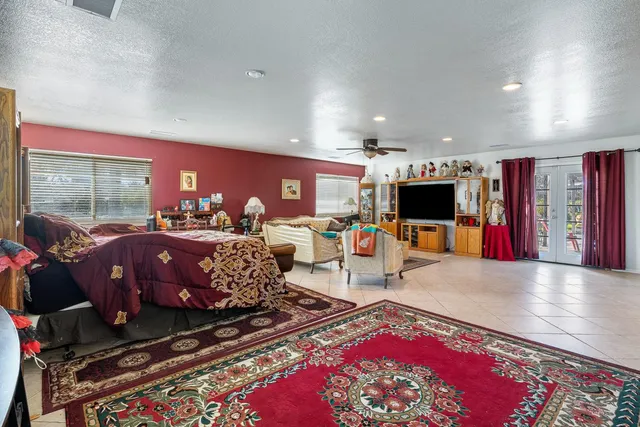 a living room with furniture a flat screen tv and a floor to ceiling window