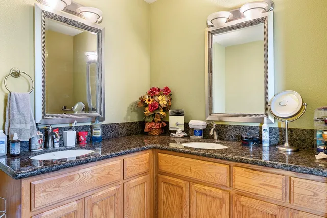 a bathroom with a granite countertop sink and a mirror
