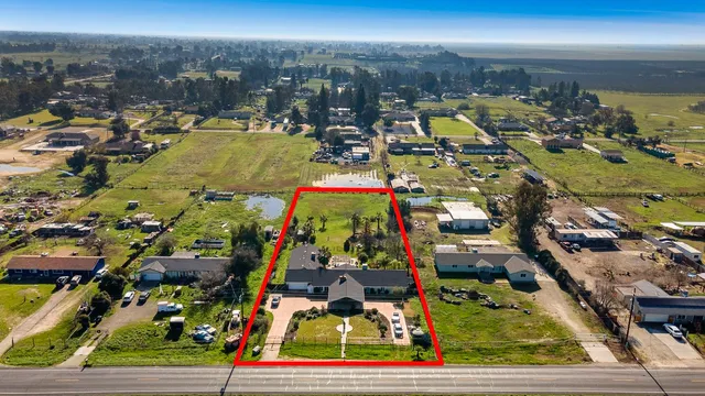 an aerial view of residential houses with outdoor space and parking